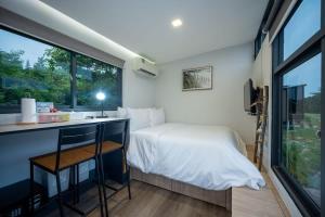 a bedroom with a bed and a desk and a window at Tiny Away Escape at Lazarus - 2017 in Singapore