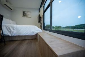 a bedroom with a bed and a large window at Tiny Away Escape at Lazarus - 2017 in Singapore