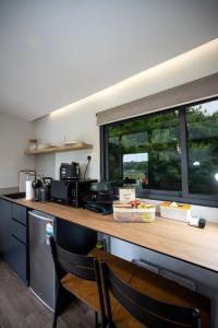 a kitchen with a counter with a table and a window at Tiny Away Escape at Lazarus - 2017 in Singapore