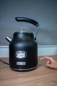 a black slow cooker sitting on a wooden table at Tiny Away Escape at Lazarus - 2017 in Singapore
