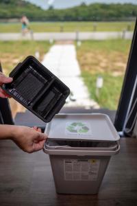 a person holding a container in a trash can at Tiny Away Escape at Lazarus - 2017 in Singapore