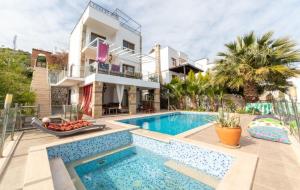 a villa with a swimming pool in front of a house at Villa Selen in Bogazici