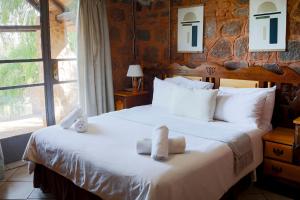 a bedroom with a bed with towels on it at Riverman Cabin Country Lodge - Tonteldoos in Tonteldoos