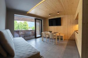 Cette chambre comprend un lit, une table et une télévision. dans l'établissement Alpine Nest Bovec, à Bovec