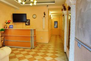 a hallway with a television and a checkerboard floor at Fortuna Hotel in Utes