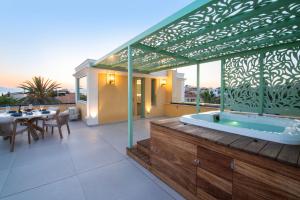 a house with a jacuzzi tub on a deck at Grypes Deluxe Complex in Egina
