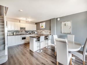 a kitchen with white cabinets and a table and chairs at Cottage 5 - Uk38221 in Ashby cum Fenby