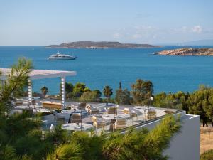 a view of a resort with a cruise ship in the water at The Roc Club, A Grecotel Hotel to Live in Athens