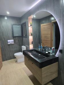 a bathroom with a black sink and a toilet at Tropical lagon in Nosy Be