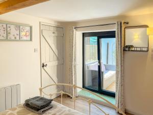 a bedroom with a bed and a large window at Hop Cottage in Sellindge +6 photos