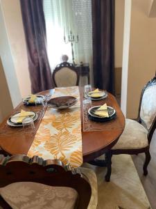a wooden table with plates and napkins on it at Apartment Sanda 72 in Gevgelija +3 photos