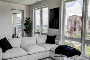 un sofá blanco en una sala de estar con ventanas en Upscale Midtown Retreat , Free Parking & Close to Mercedes-Benz, en Atlanta