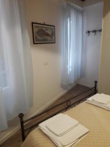 a room with two beds and a window with white curtains at raggio di sole dietro piazza San Marco in Venice