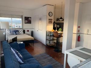 a living room with a blue couch and a bedroom at BELVEDERE SUITE in Faro