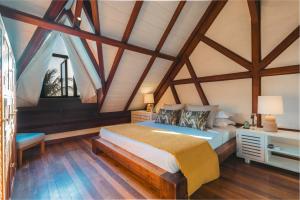 a bedroom with a bed with a wooden ceiling at Villa Matahari by muse villas in Rivière Noire +42 photos