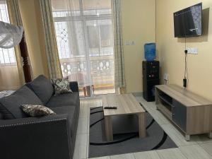 a living room with a couch and a table at Comfy Apartments in Mombasa