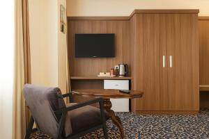 a hotel room with a table and a chair and a television at Hotel zum Weissen Ochsen in Aalen