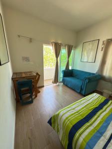 a bedroom with a bed and a couch and a table at Casa Pax - Hab El Rincón del Pescador Frente al Mar in La Paz