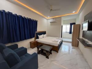 Una habitación con una cama, un sofá y un televisor. en Hotel Rajasthan Royals, en Hyderabad
