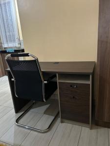 a desk with a chair next to a wooden desk at Comfy Apartments in Mombasa +4 photos