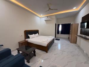 Un dormitorio con una cama, un sofá y un televisor. en Hotel Rajasthan Royals, en Hyderabad