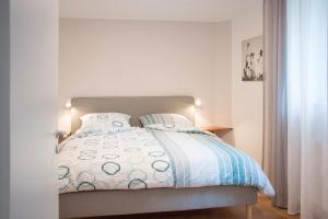 a bedroom with a bed with a blue and white comforter at Ferienwohnung Auszeit in Salem