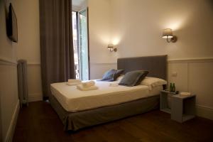 una camera da letto con un letto con asciugamani sopra di Relais della Torre a Roma