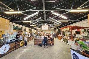 a group of people standing in a grocery store at Harborlight--Modern 2 Bedroom Townhouse in Hobsonville in Auckland