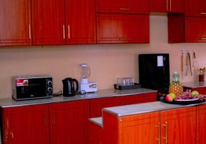 KisiiEntire Fully furnished Villas in Kisii的厨房里有红色的橱柜，柜台上放着一盘水果 更多12张照片