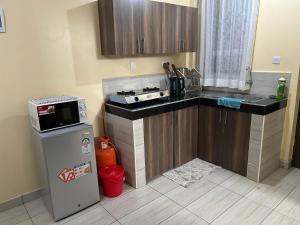 a small kitchen with a stove and a refrigerator at Comfy Apartments in Mombasa