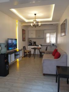 un salon avec un canapé blanc et une cuisine dans l'établissement Blowsuites Furnished Apartment, à Lotus Island