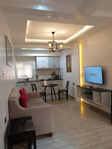 un salon avec un canapé et une cuisine dans l'établissement Blowsuites Furnished Apartment, à Lotus Island