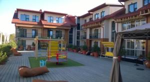 a playground in the courtyard of a building at Bears Apartments in Palanga