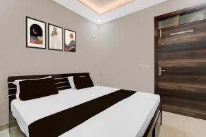 1 dormitorio con 1 cama grande y puerta de madera en HOTEL O Raghav Vaidehi Inn, en Chinhat 21 fotos más