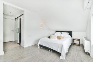 a white bedroom with a bed and a walk in shower at Cottage New Sakramulo in Karsimaantkari