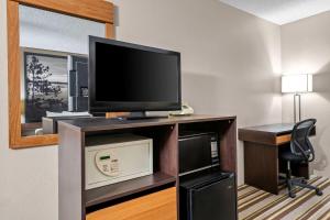 Habitación con TV y escritorio con silla. en Super 8 by Wyndham Blue Earth, en Blue Earth