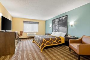 a hotel room with a bed and a flat screen tv at Super 8 by Wyndham Osseo WI in Osseo
