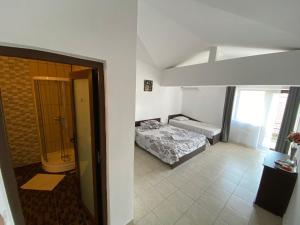 a bedroom with a bed and a bathroom with a window at Casa EVY in Eforie Nord