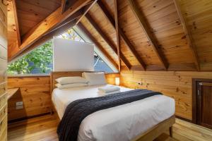 マーガレットリバーにあるTerrace Haus Margaret Riverの木造キャビン内のベッドルーム1室(大型ベッド1台付)