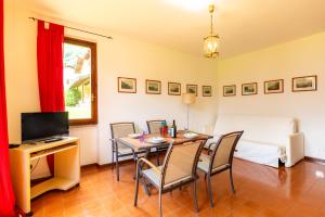 a dining room with a table and chairs and a bed at Antica Isola Giardino - Happy Rentals in Sala Comacina