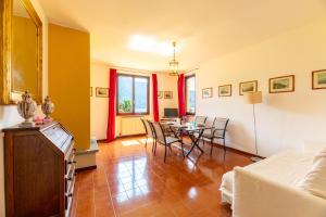 a living room with a table and chairs in it at Antica Isola Giardino - Happy Rentals in Sala Comacina