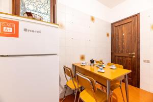 a dining room with a table and a refrigerator at Antica Isola Giardino - Happy Rentals in Sala Comacina +18 photos