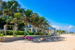 a beach with palm trees and a pink swing at Lan Rung Beach Resort in Long Hai +164 photos