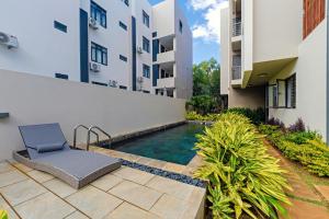 a swimming pool with a chair next to a building at Ecostay Apartment in Midlands Station