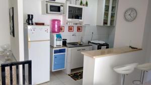 una pequeña cocina con nevera y fregadero en Apartamento Bonavides, en Fortaleza