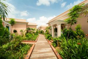 a walkway leading to a house with plants at Dolce Vita - Luxury Vacation Villas in Pushkar