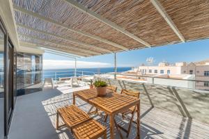 a table and chairs on a balcony with a view of the ocean at Nomad Hub Tenerife in Barranco Grande
