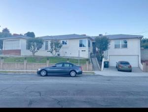 dos autos estacionados en un estacionamiento frente a una casa en Room in Monterey Park CA, en Monterey Park