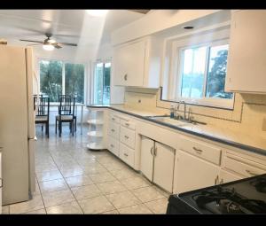 cocina con armarios blancos y comedor en Room in Monterey Park CA, en Monterey Park