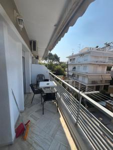 a balcony with a table and chairs on a building at Summer Holidays in Nea Kalikratia